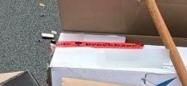 een close-up van de "breekbaar"-tape op de verhusidoos