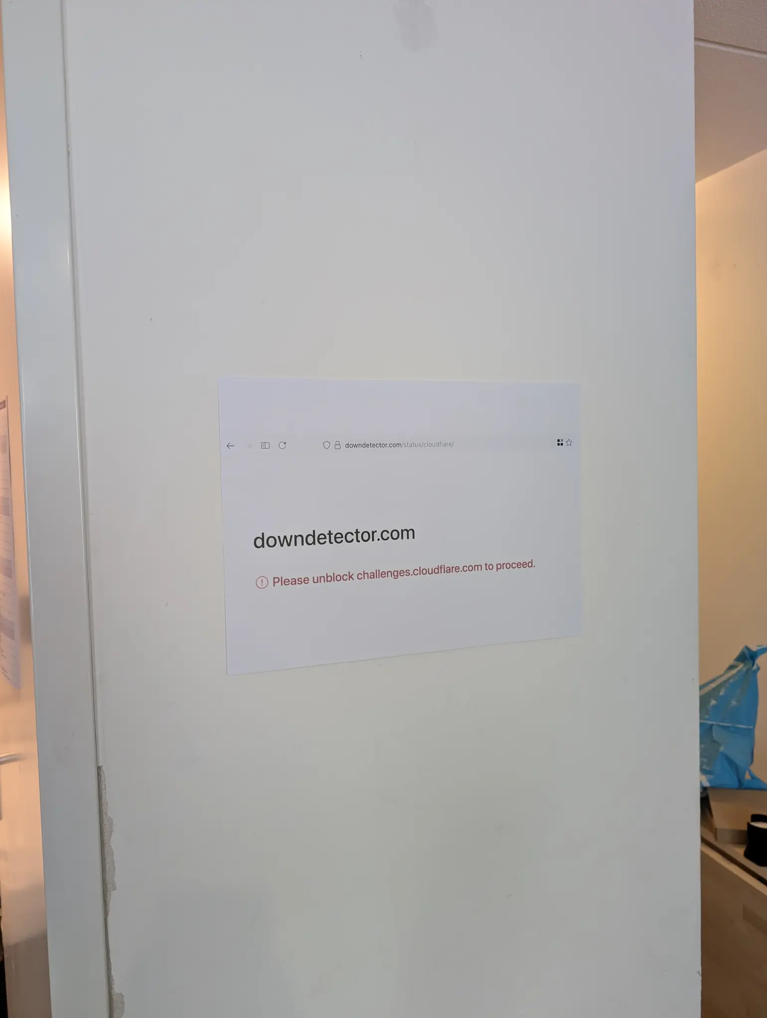 screenshot of downdetector.com being down because of cloudflare printed out on A3 and hung on a wall
