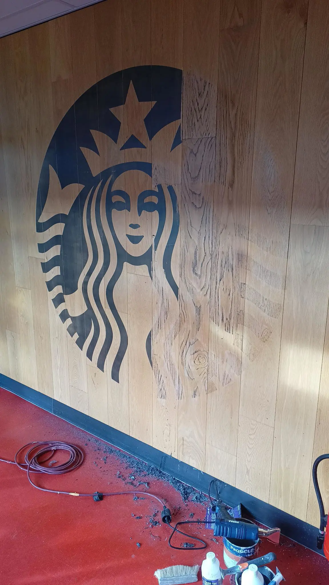 Starbucks logo being removed from a wall